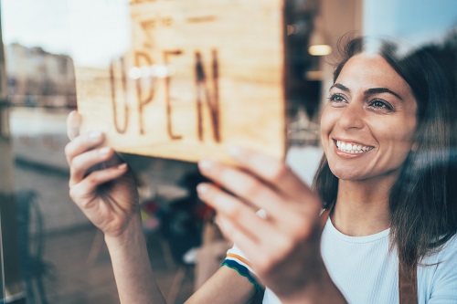 business owner turning open sign